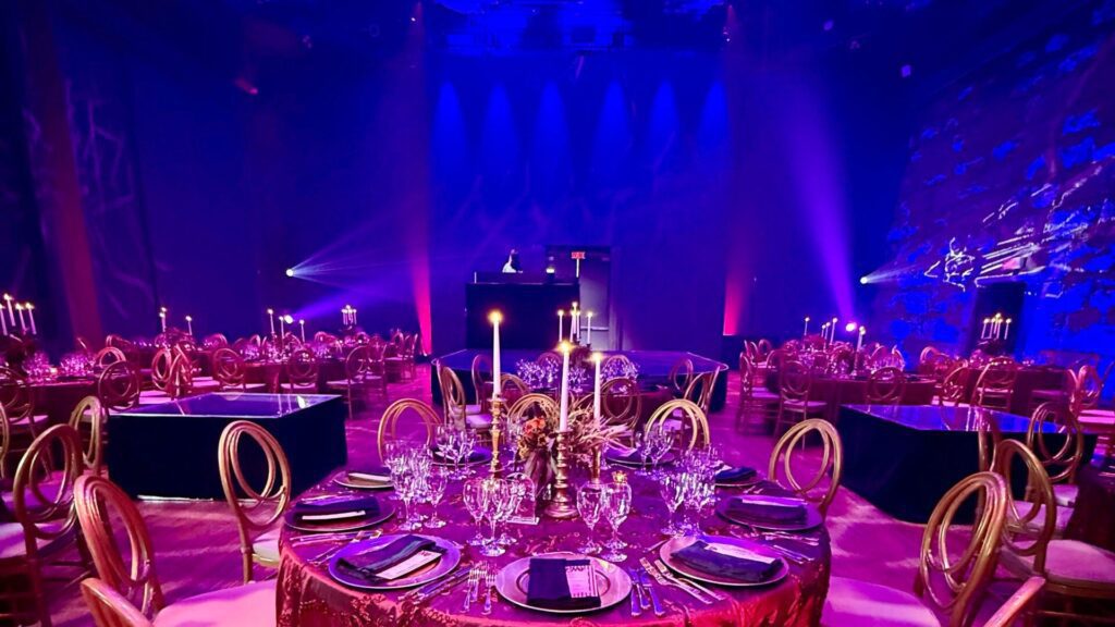 Cirque Éloize venue lit in blue and purple, with tables set with candles.